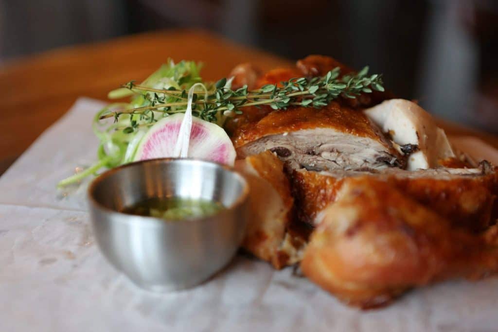 Chicken breast roasted with rosemary and green dipping sauce in metal dipping cup