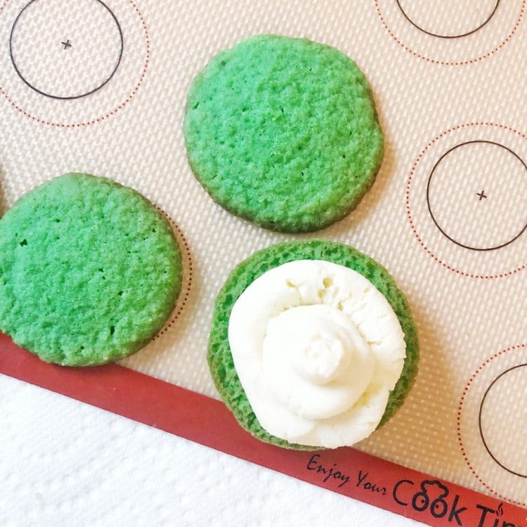 green whoopie pies with cream cheese filling half cookie on baking sheet
