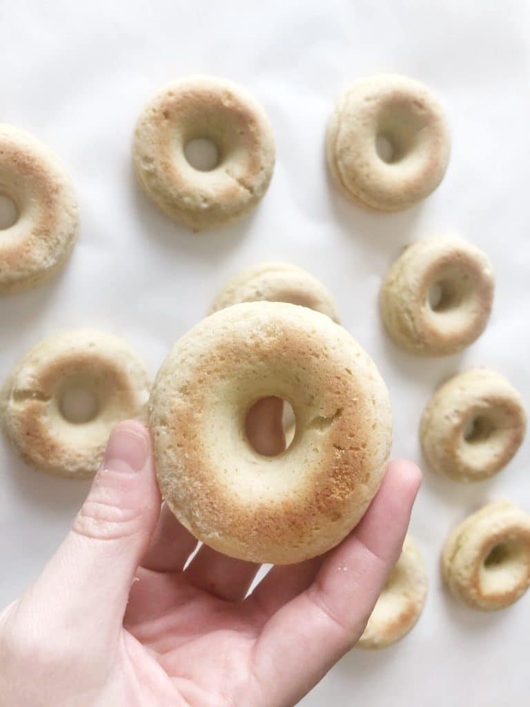 unglazed donuts holding one in hand