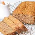 sliced keto spice cake with creamer container filled with cinnamon sticks on a baking sheet