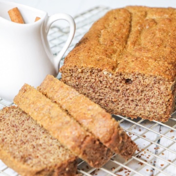 sliced keto spice cake with creamer container filled with cinnamon sticks on a baking sheet