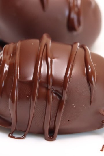 a close-up side view of keto chocolate peanut butter eggs with white background