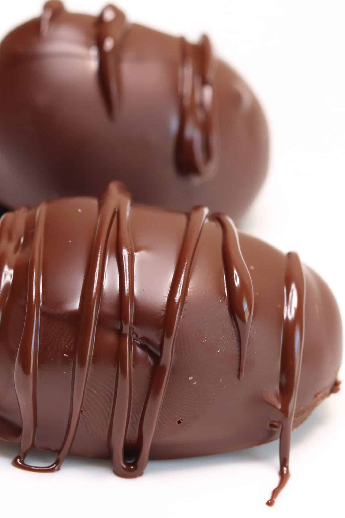 a close-up side view of keto chocolate peanut butter eggs with white background