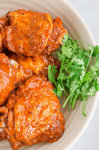 chicken thighs on white plate with parsley