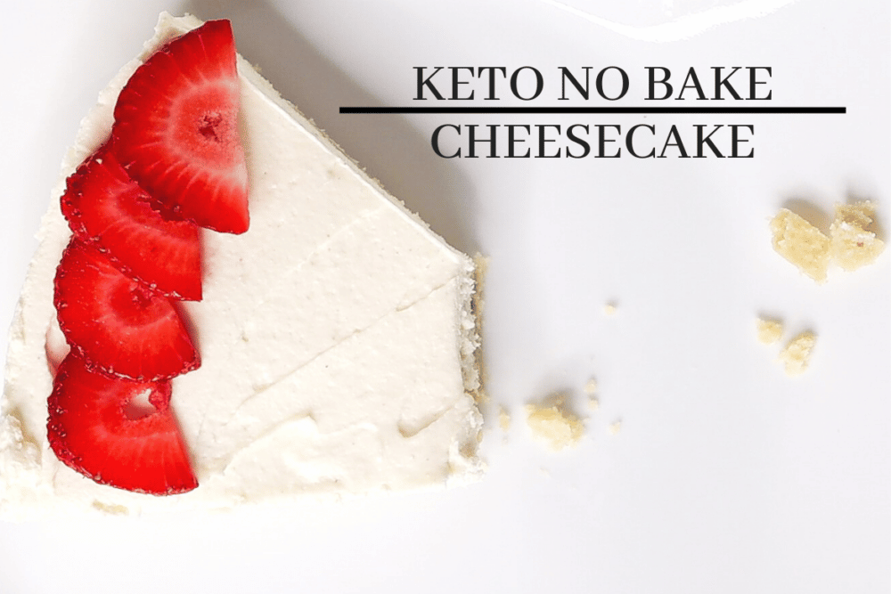 keto no-bake cheesecake on white plate with sliced strawberries and bite taken out of it