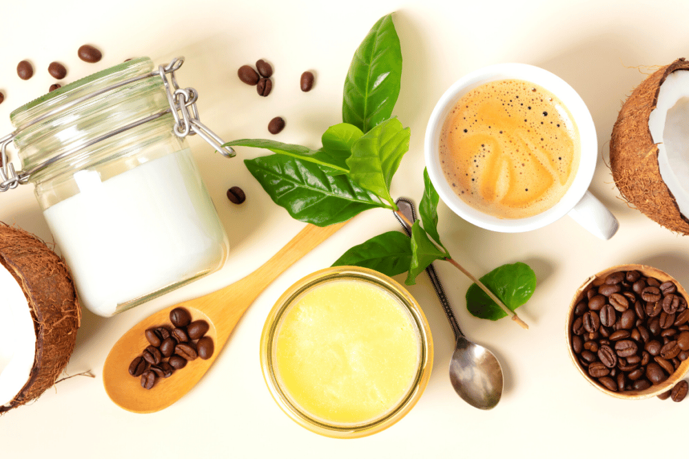 keto coffee with butter, coconut, coffee beans, and green leaves