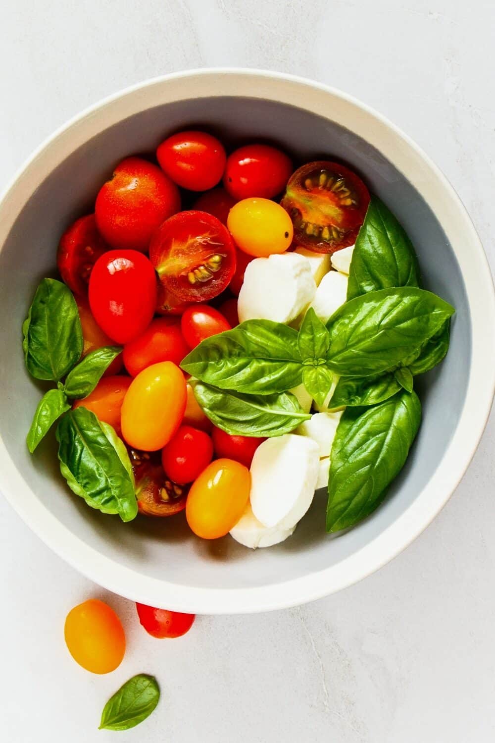 Elegant Caprese salad with layers of ripe, juicy tomatoes, fresh basil leaves, and creamy mozzarella slices, drizzled with balsamic glaze and olive oil, showcasing a classic, keto-friendly Italian dish in all its vibrant colors and textures