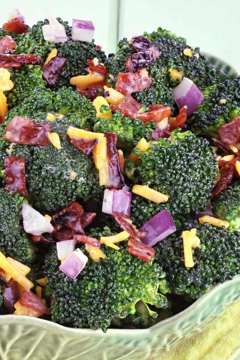 A vibrant salad bursting with colors and flavors. Crisp broccoli florets are combined with crispy bacon pieces, creating a delightful contrast. Tossed in a tangy dressing, this salad offers a perfect blend of textures and tastes. A scattering of sunflower seeds adds a satisfying crunch, making it a refreshing and savory dish