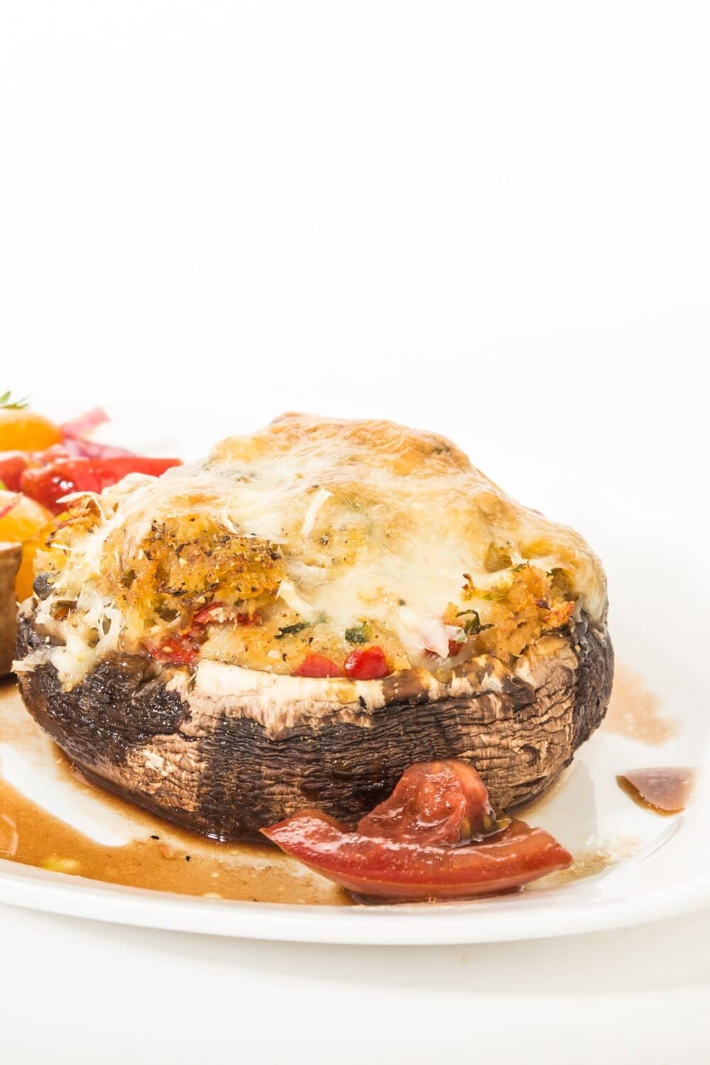Caprese Stuffed Portobello Mushrooms, a delightful vegetarian dish. Large, meaty Portobello mushrooms are generously filled with a classic Caprese combination of fresh mozzarella cheese, ripe tomato slices, and fragrant basil leaves. The mushrooms are baked to perfection, resulting in a savory and gooey texture. This visually appealing dish is a burst of flavors, showcasing the perfect balance of tangy cheese, juicy tomatoes, and aromatic herbs.