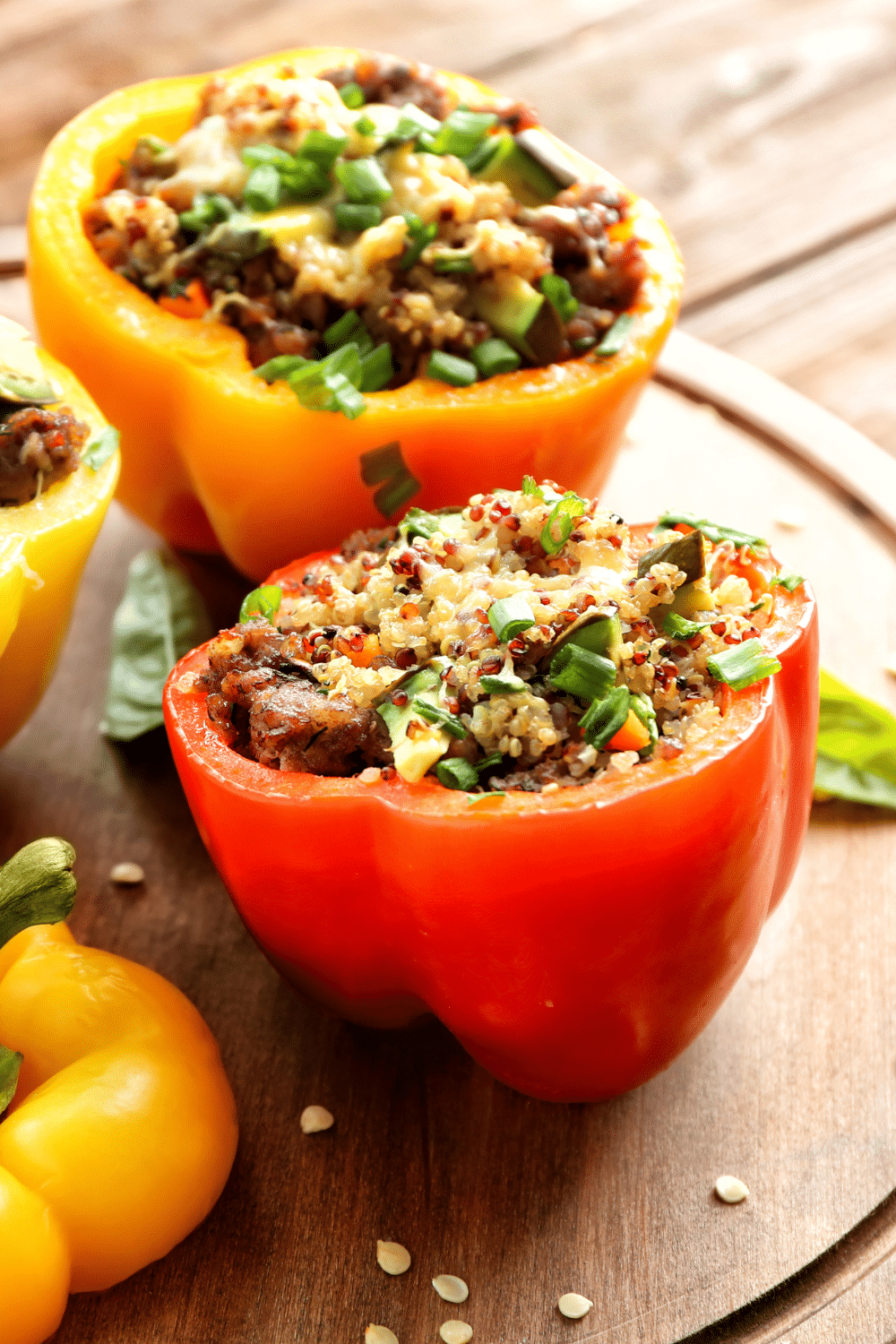 A tantalizing image of stuffed peppers filled with savory spiced quinoa. The vibrant red and green bell peppers are beautifully arranged on a plate, showcasing the colorful presentation of this delicious dish. The quinoa is perfectly seasoned, offering a flavorful and wholesome filling. This appetizing meal is both visually appealing and packed with nutritious ingredients.
