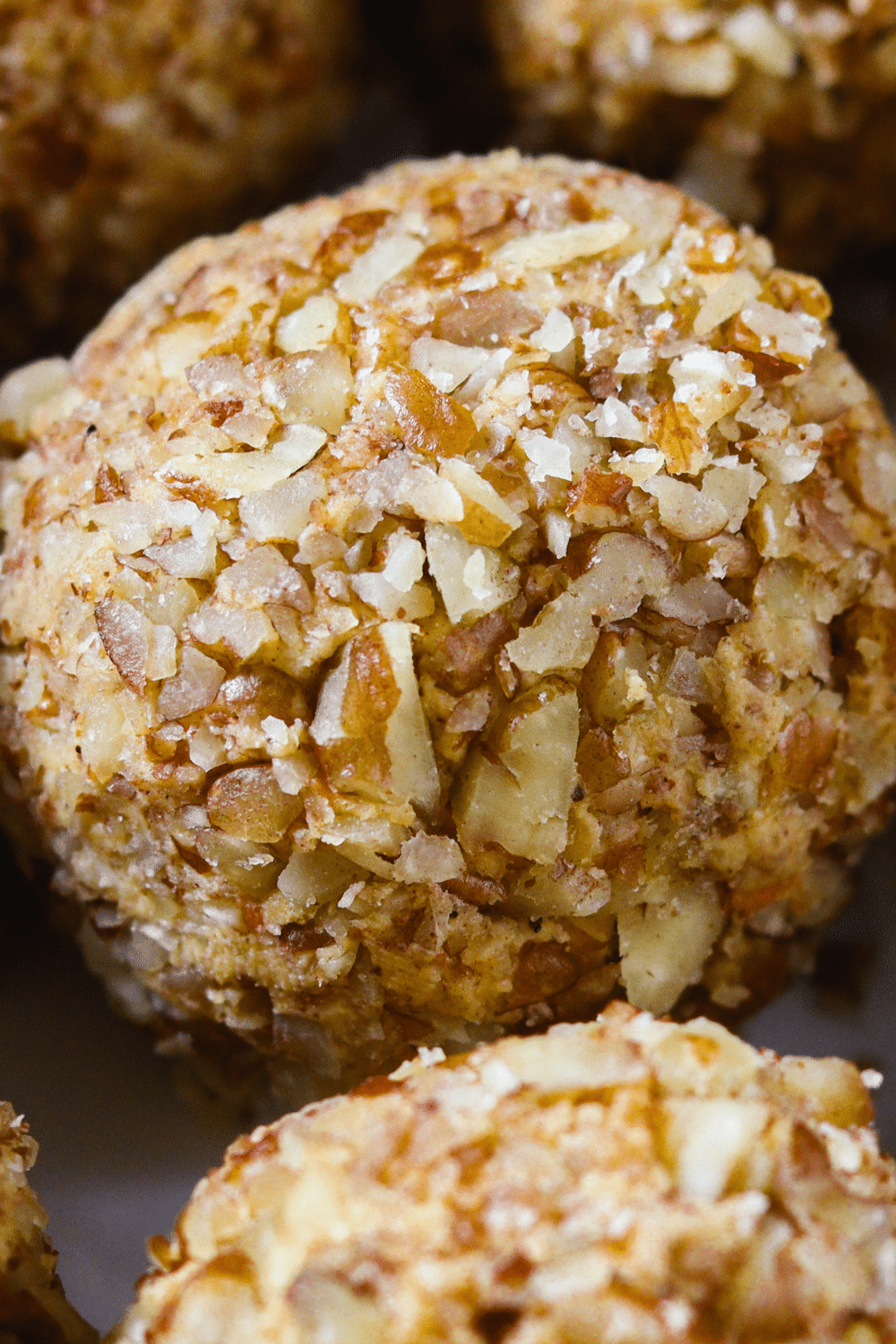 This close-up image captures the alluring details of carrot cake keto fat bombs. The fat bombs are expertly crafted, resembling miniature carrot cake bites. The foreground showcases a cluster of fat bombs, allowing us to admire their intricate textures and vibrant colors. Each fat bomb is compact and dense, with a moist and crumbly appearance reminiscent of traditional carrot cake. The exterior is adorned with finely grated carrots, adding a touch of visual appeal and a hint of earthy flavor. The fat bombs are delicately spiced with warm notes of cinnamon and nutmeg, further enhancing the resemblance to the beloved carrot cake dessert. With their low-carb and keto-friendly ingredients, these carrot cake fat bombs provide a guilt-free alternative to satisfy cravings while adhering to a ketogenic diet.