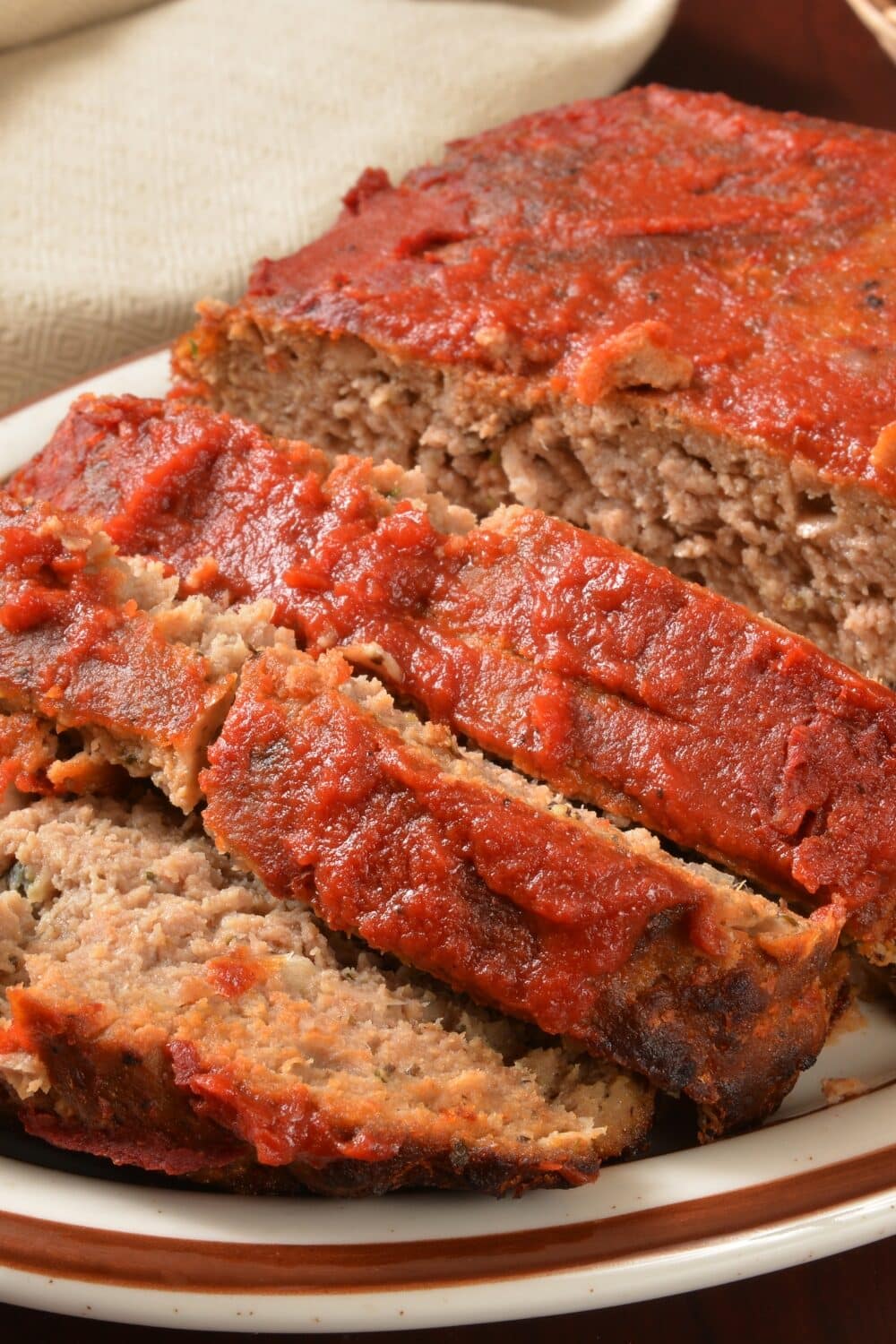 Savory keto meatloaf, expertly seasoned and baked to perfection, crowned with a glaze of sugar-free ketchup. The meatloaf boasts a flavorful blend of premium meats and low-carb binders, creating a moist and delectable texture. The glossy ketchup topping adds a tangy, slightly sweet contrast, making each slice a delightful, guilt-free indulgence.