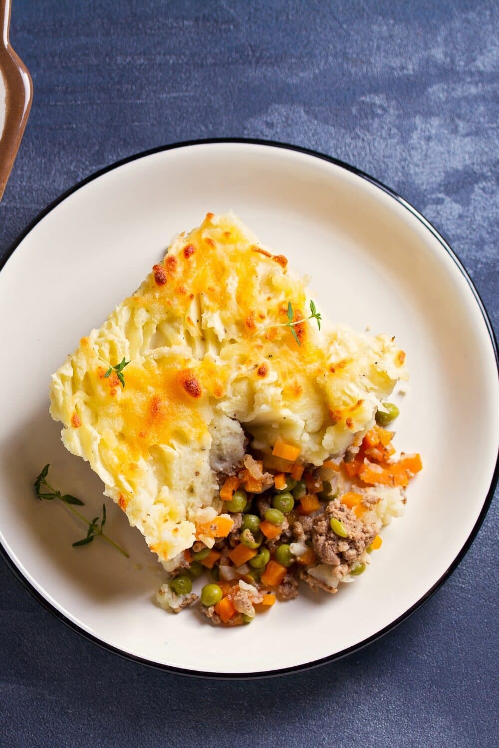 Keto cottage pie featuring a luscious filling of seasoned ground meat and vegetables, topped with a smooth layer of creamy cauliflower mash. The golden-brown topping offers a comforting contrast to the savory, hearty base. This low-carb twist on a traditional favorite delivers both flavor and indulgence while adhering to a keto lifestyle.