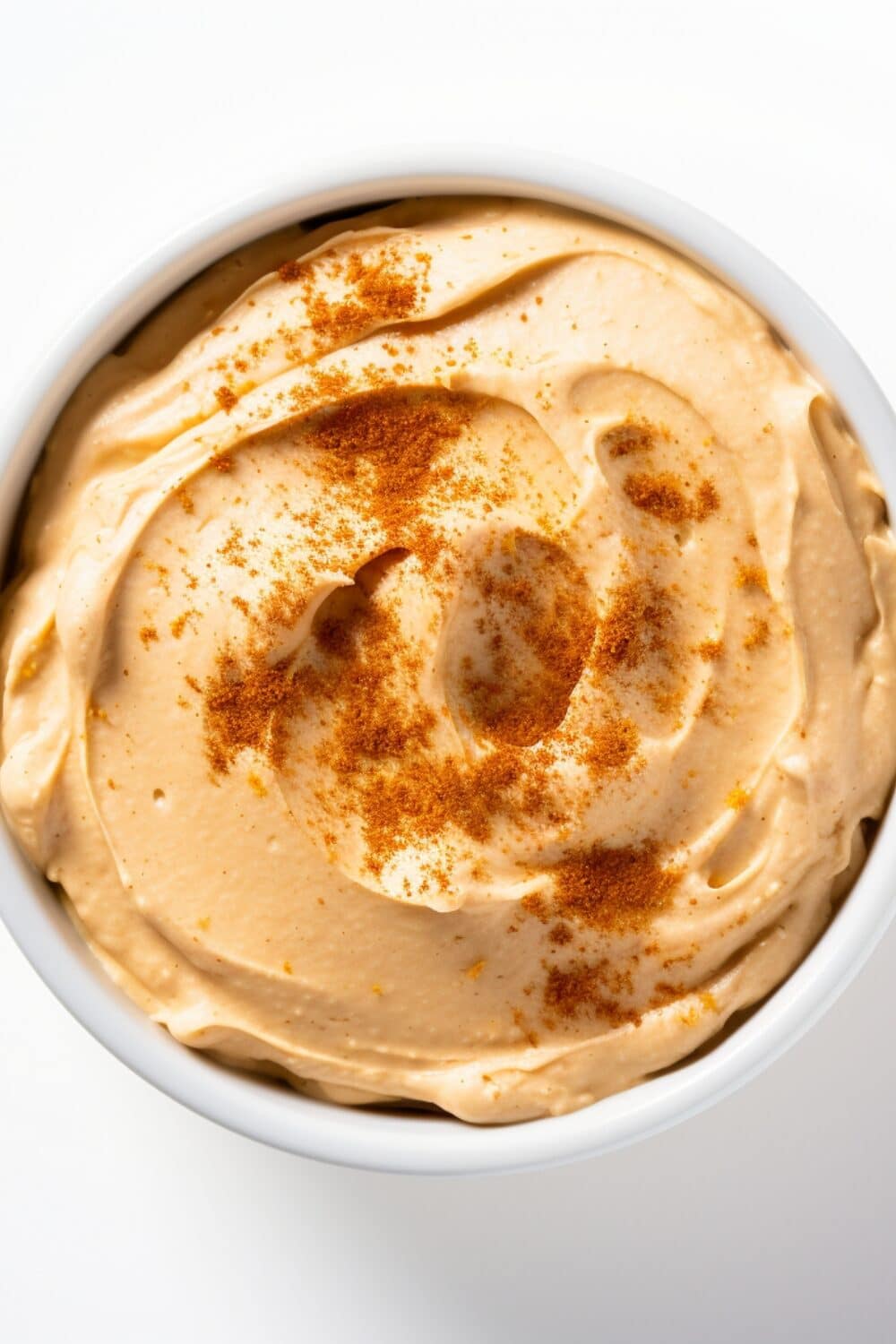 A bowl of creamy pumpkin cheesecake dip, topped with cinnamon
