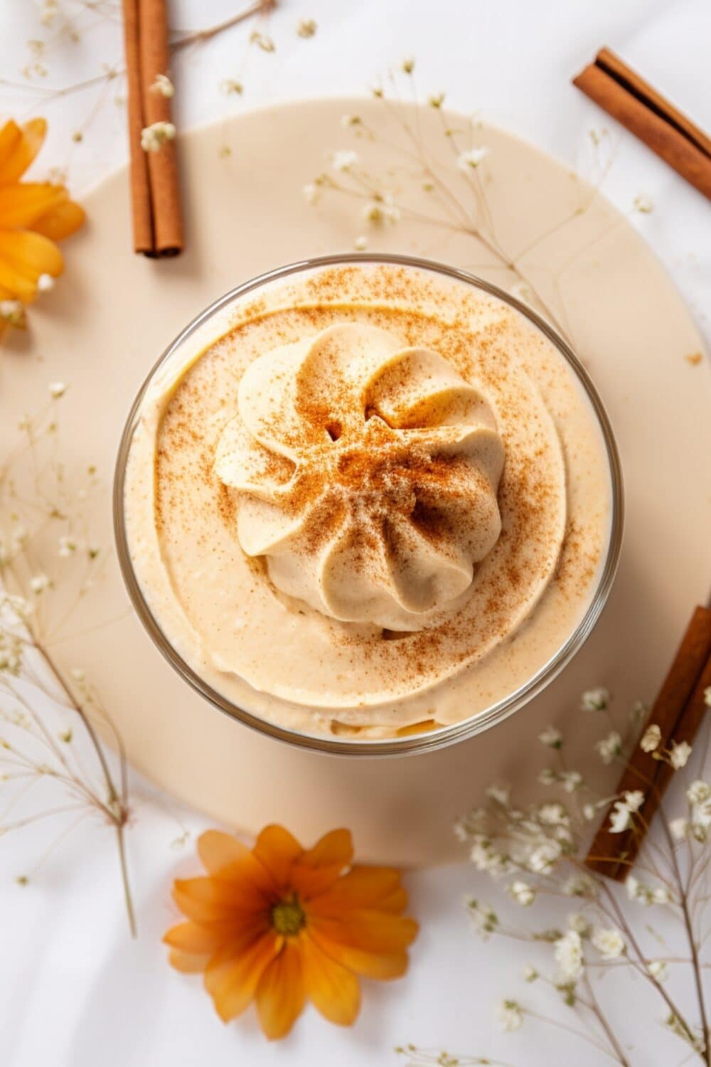 A dessert glass filled with light and airy pumpkin mousse, topped with whipped cream and cinnamon.