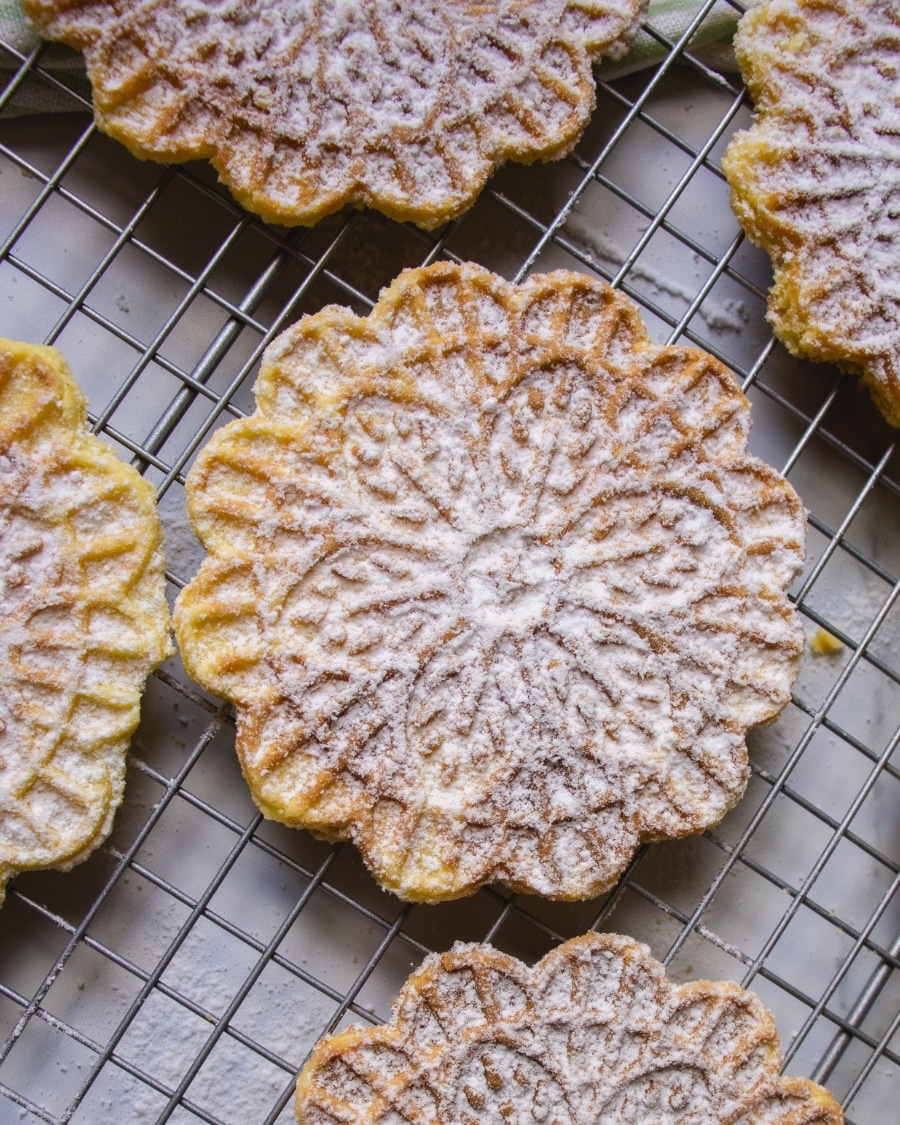 close-up of all keto pizzelle cookies dusted with sugar free powdered sweetener, ready to eat