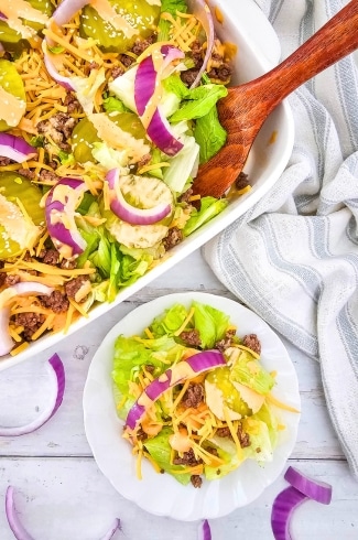 Keto Big Mac Salad in a casserole dish with wooden spoon, and on a plate single serving