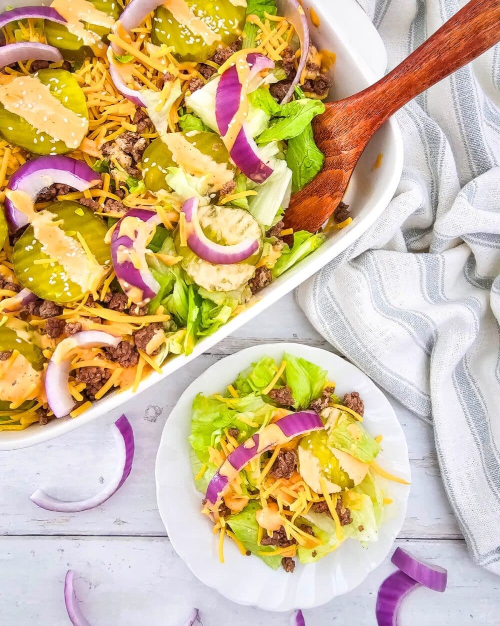 Keto Big Mac Salad in a casserole dish with wooden spoon, and on a plate single serving