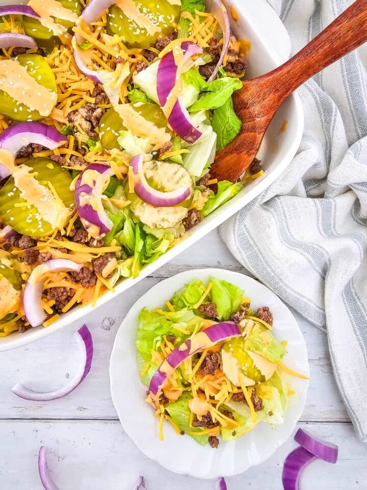 Keto Big Mac Salad in a casserole dish with wooden spoon, and on a plate single serving