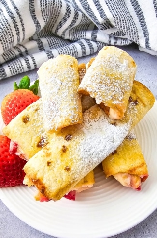 Keto Air Fryer Strawberry Cheesecake Roll Ups on a plate with strawberries