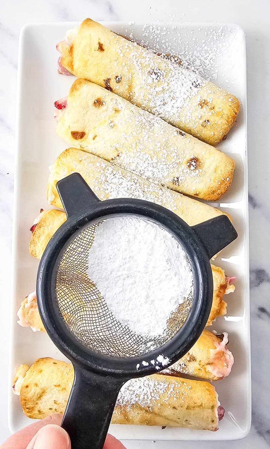 dusting strawberry roll-ups with powdered sweetener