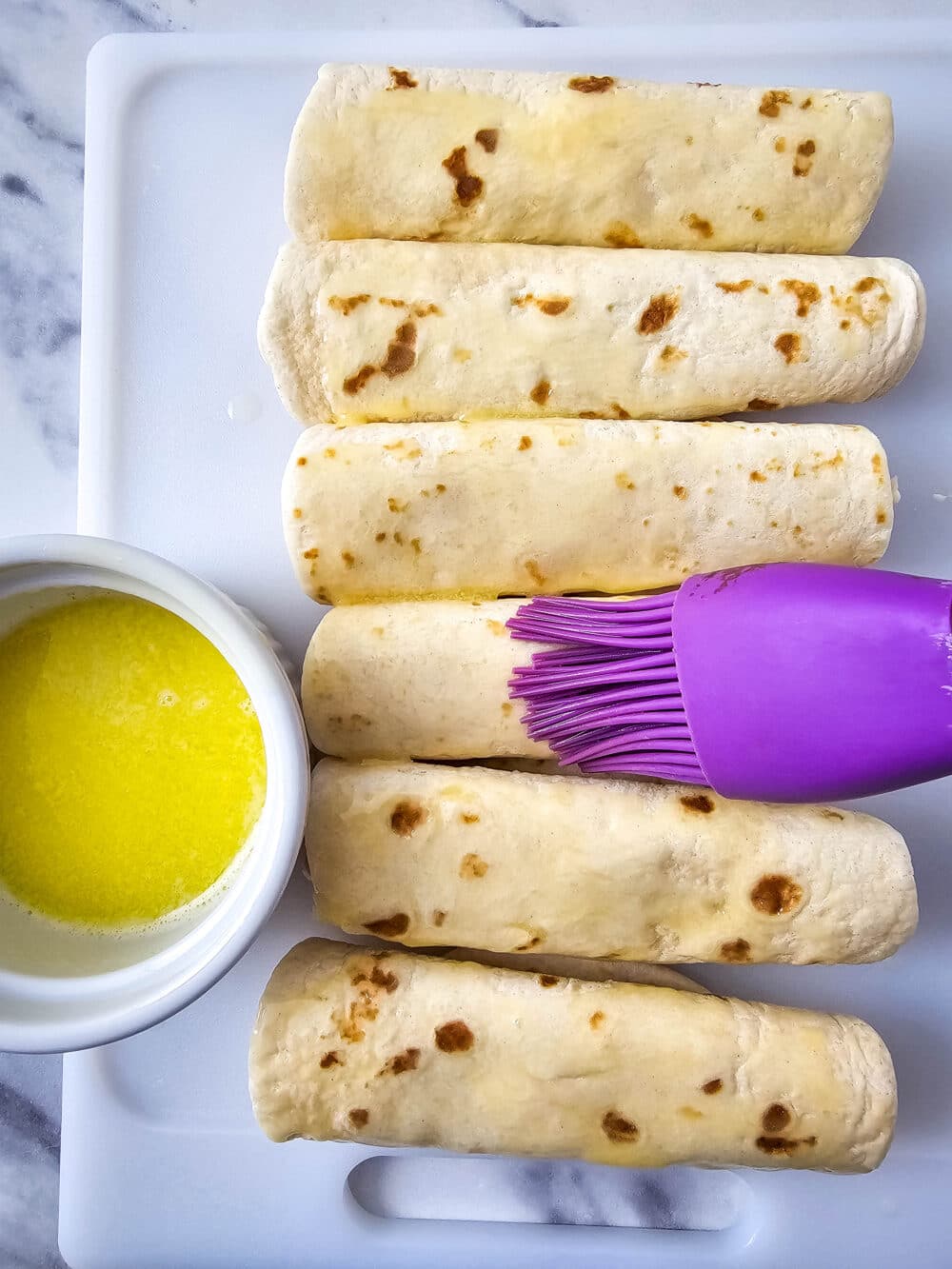 brushing tortillas with butter