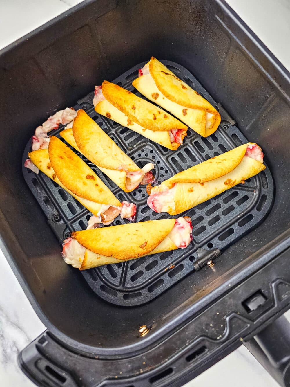 fresh cooked strawberry roll-ups in air fryer basket