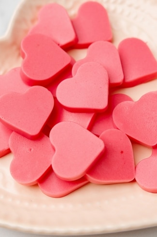 close up of keto strawberry heart-shaped gummies on a plate