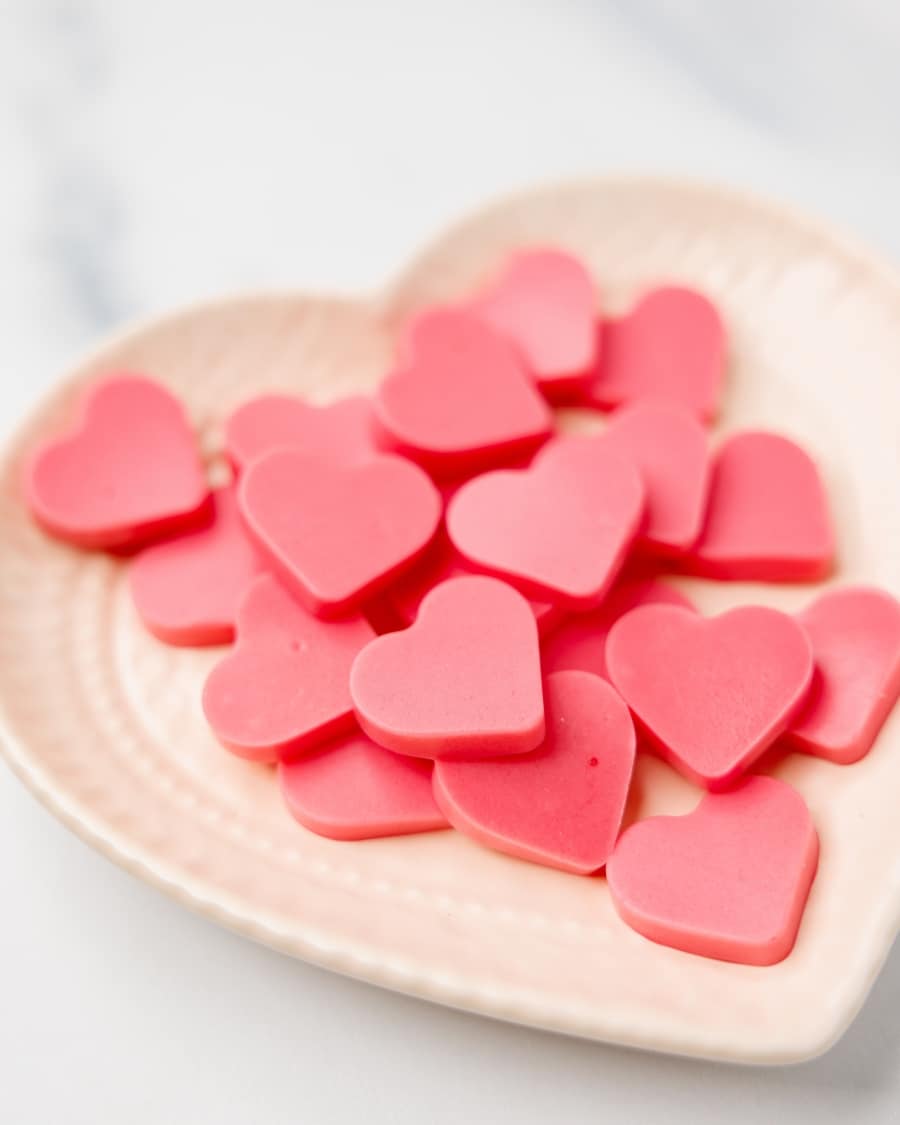 wide shot of keto strawberry heart-shaped gummies on a plate