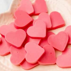 close up of keto strawberry heart-shaped gummies on a plate
