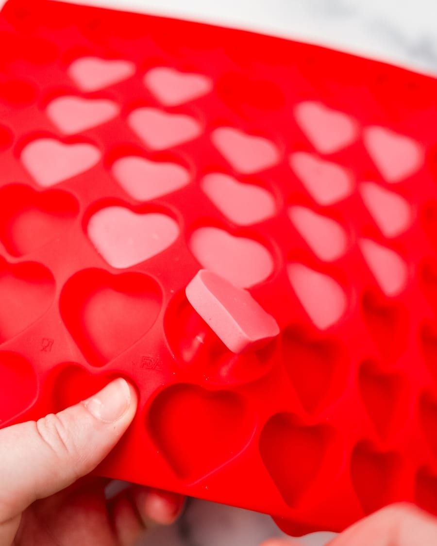 taking Keto Strawberry Gummies out of mini heart-shaped red silicone mold