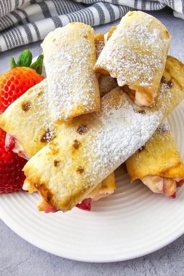 Keto Air Fryer Strawberry Cheesecake Roll Ups on a plate with strawberries