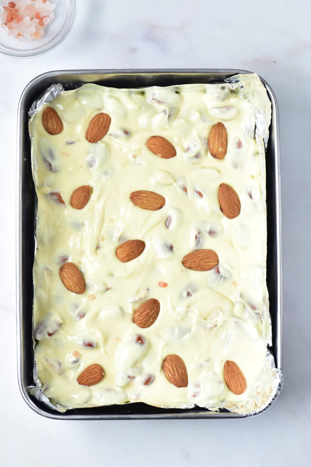 Keto White Chocolate Almond Bark in a pan ready for freezer or fridge