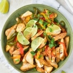 Easy Chicken Fajitas with lime and pepper slices in a green bowl overhead view