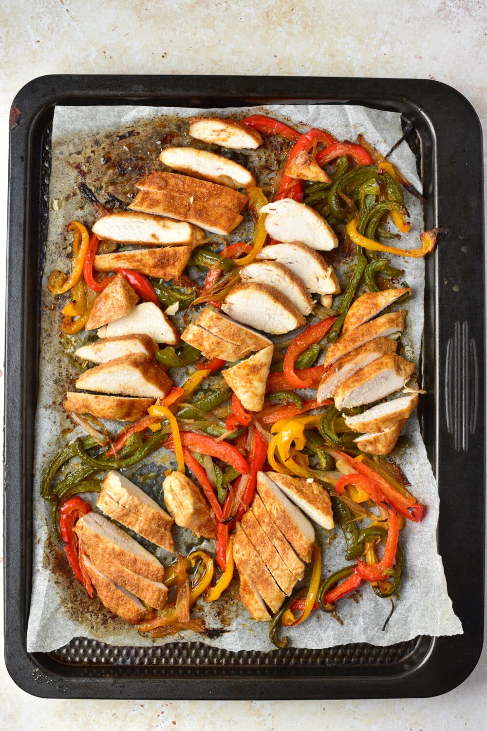 cooked and sliced chicken fajitas on sheet pan from the oven