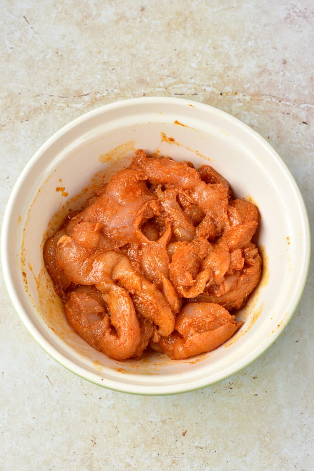 chicken marinating in a bowl