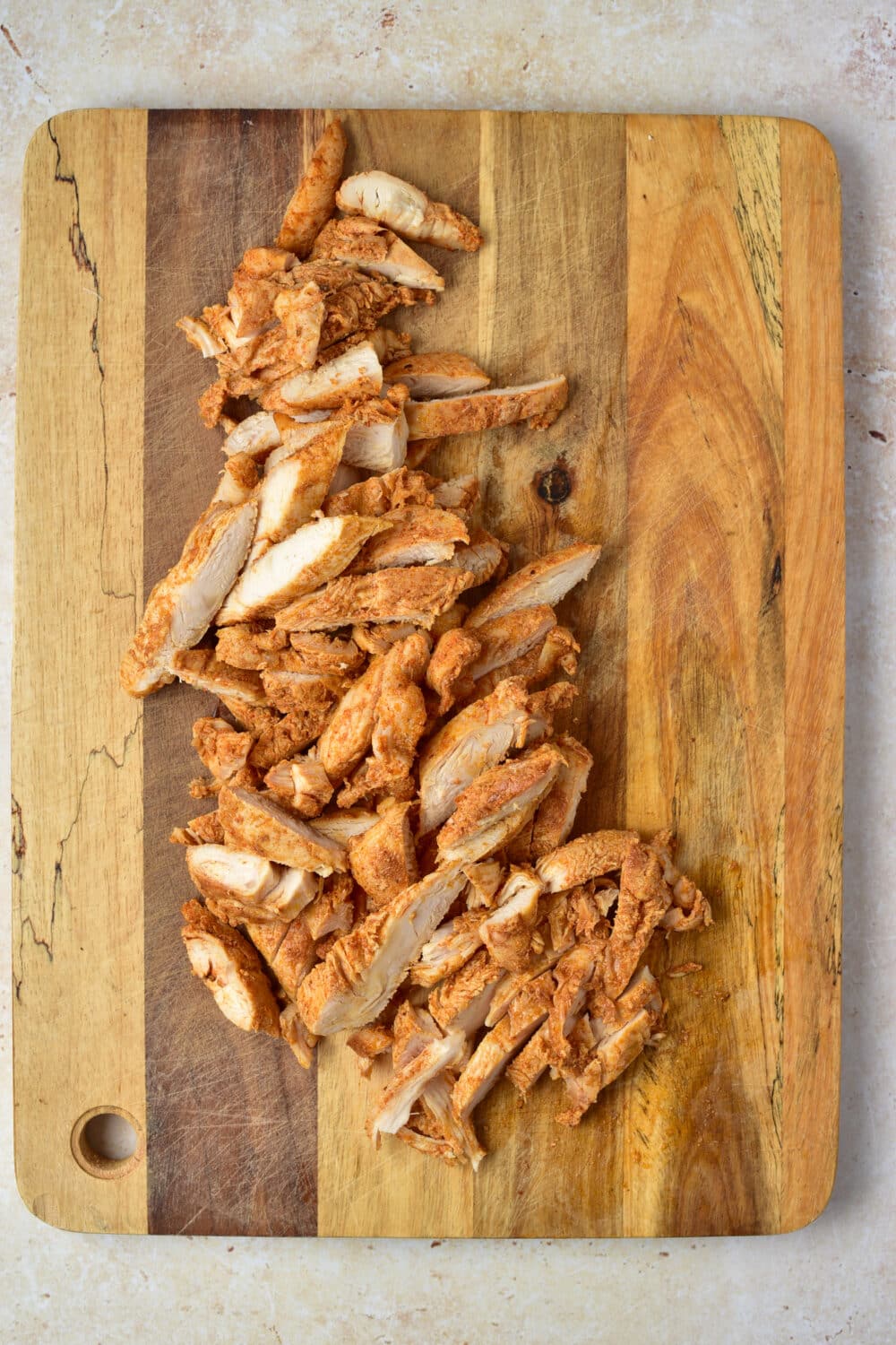 sliced cooked chicken on a cutting board