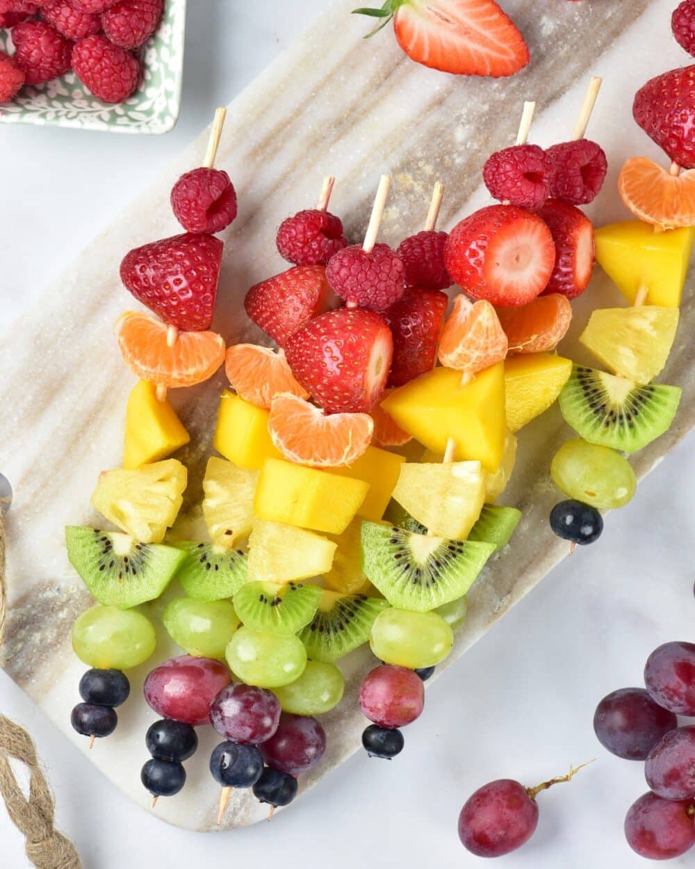 Rainbow Fruit Skewers on a gray cutting board overhead shot