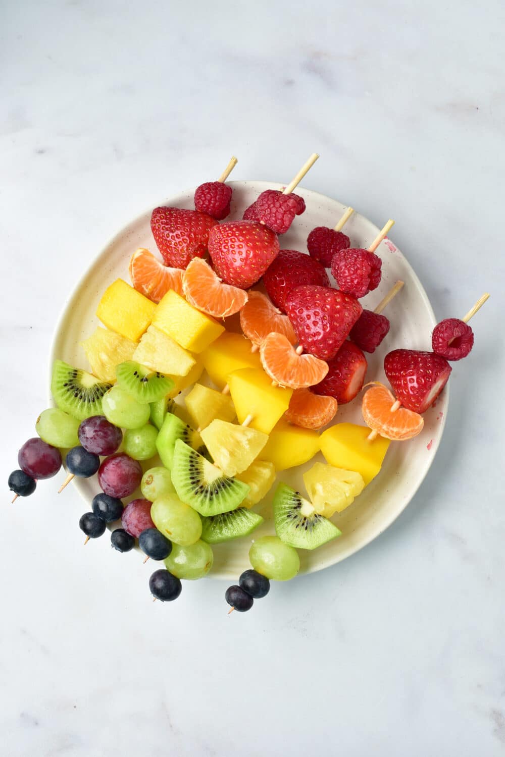 completed fruit skewers on plate overhead shot
