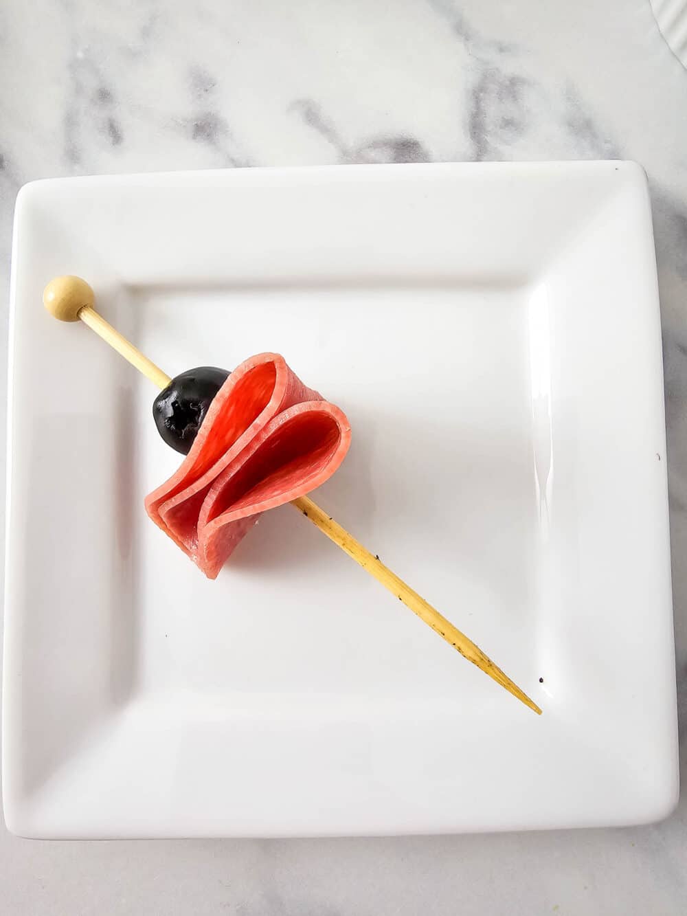 olive and salami on a skewer