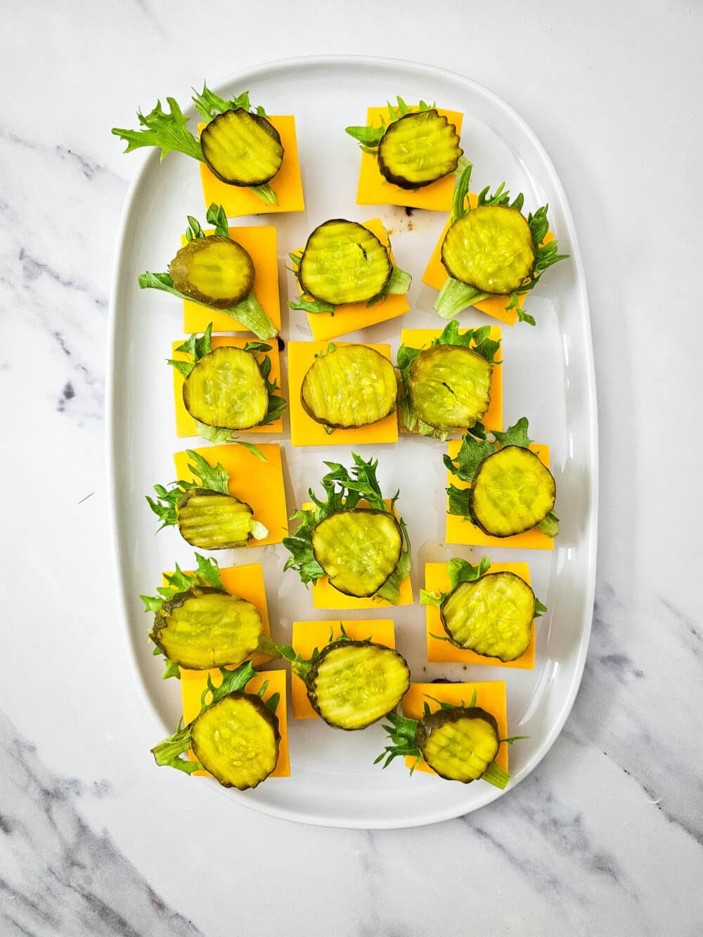 cooked ground beef mini patties topped with cheese and lettuce and pickle