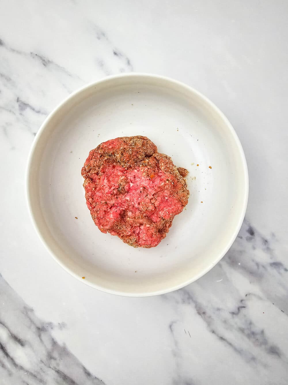 ground beef and spices in a bowl mixed