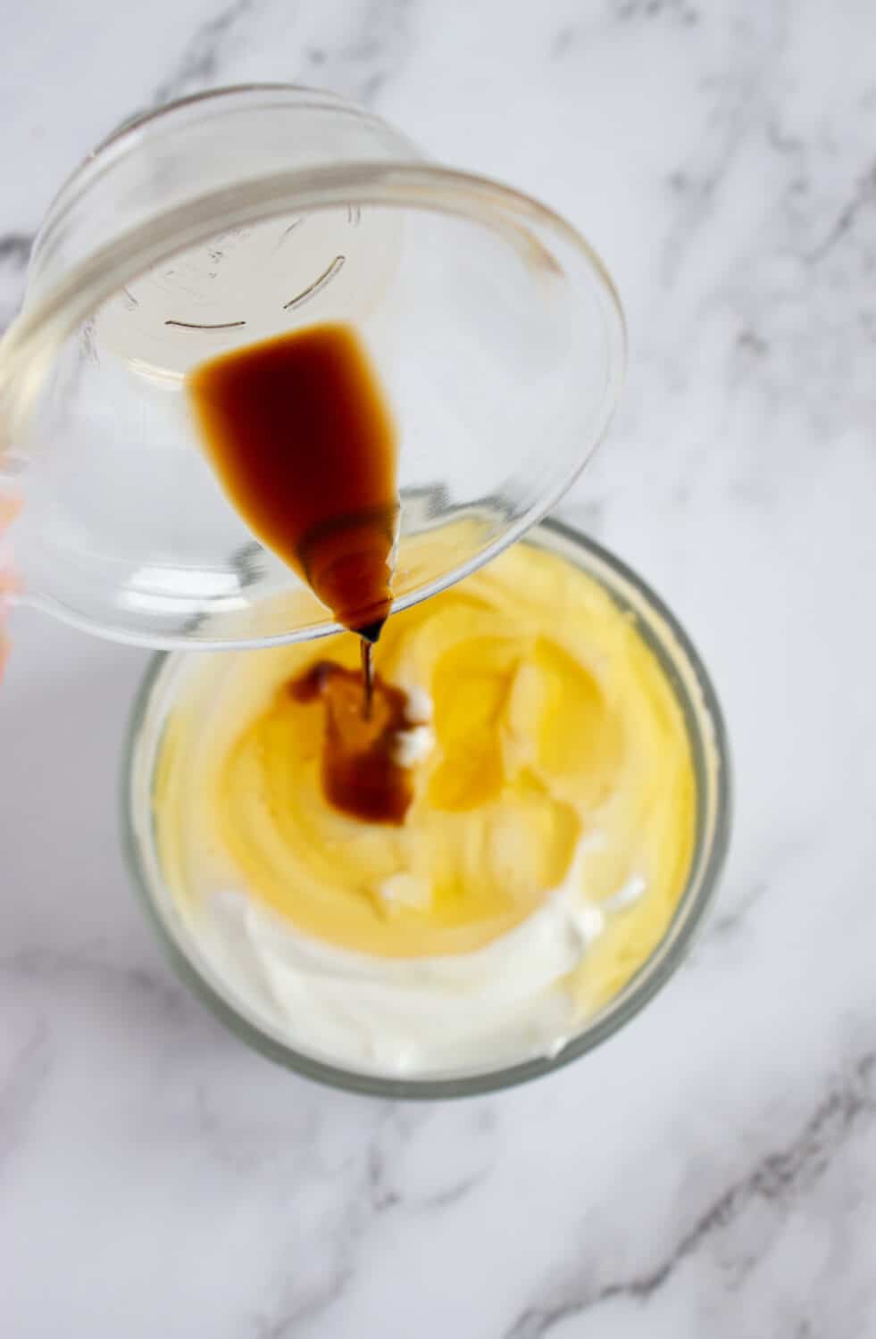 pouring vanilla extract into greek yogurt