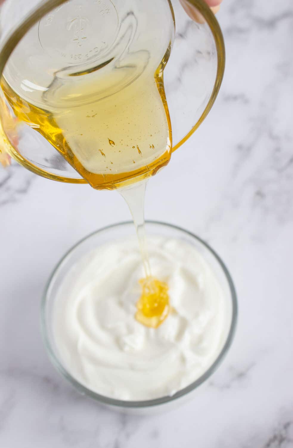 pouring sugar-free honey into greek yogurt