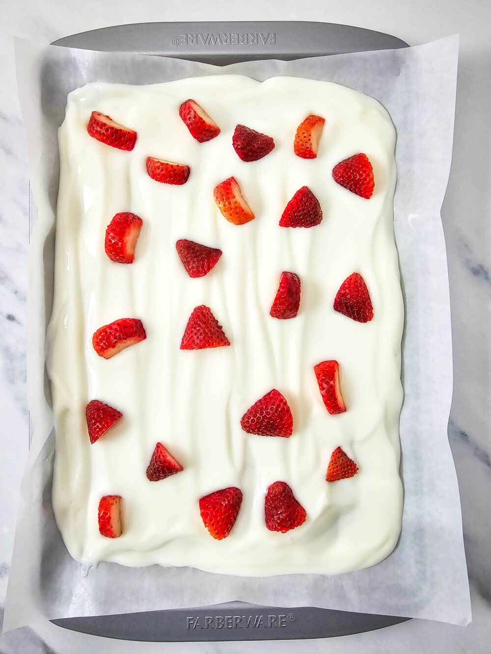 strawberries on greek yogurt on a baking pan