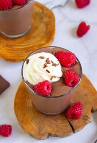Chocolate Peanut Butter Cottage Cheese Pudding on a wooden board with raspberries