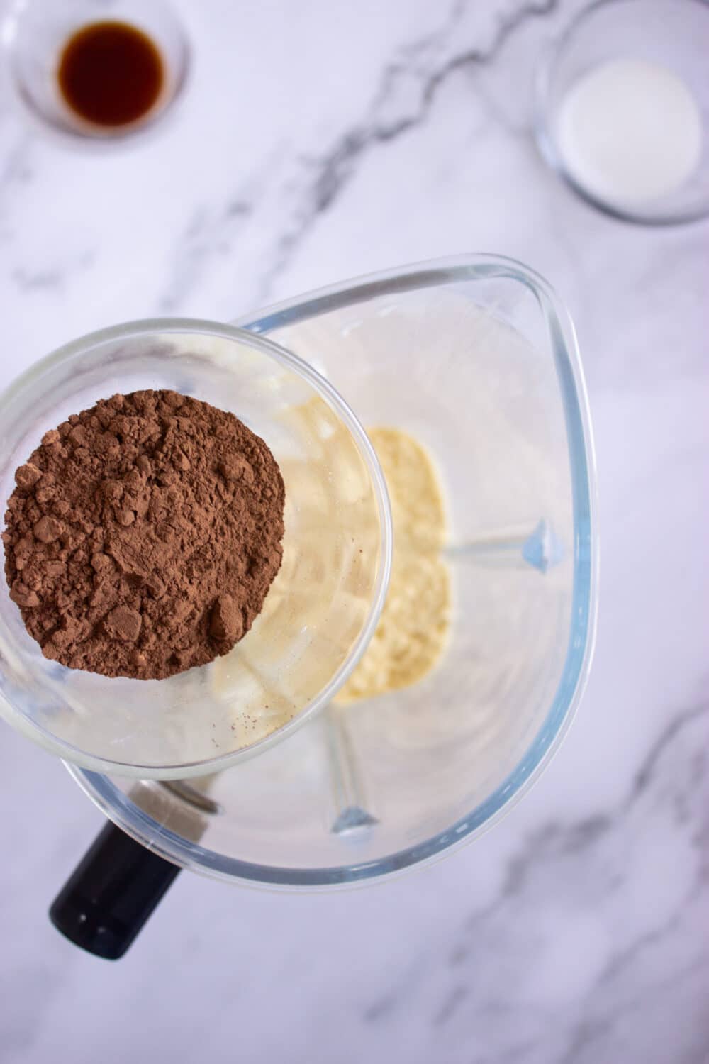 adding cocoa powder to a blender