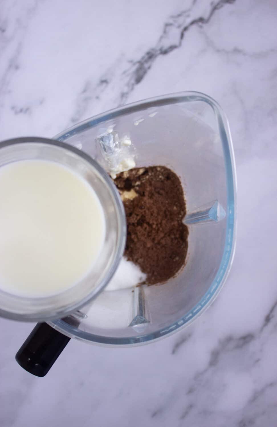 adding almond milk to a blender