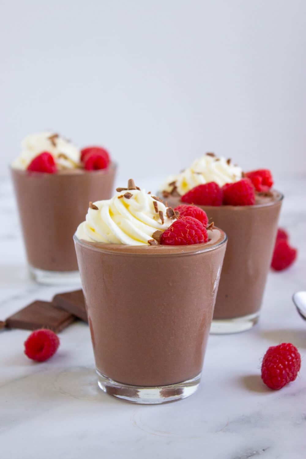 Chocolate Peanut Butter Cottage Cheese Pudding with raspberries and whipped cream on top