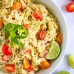High protein chicken salad with shredded chicken, cherry tomatoes, jalapeños, and lime in a white bowl.